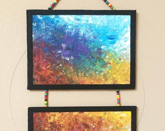 Vertical diptych 2 small multicolored cardboard panels entuffed suspended by a string of beads wall decoration