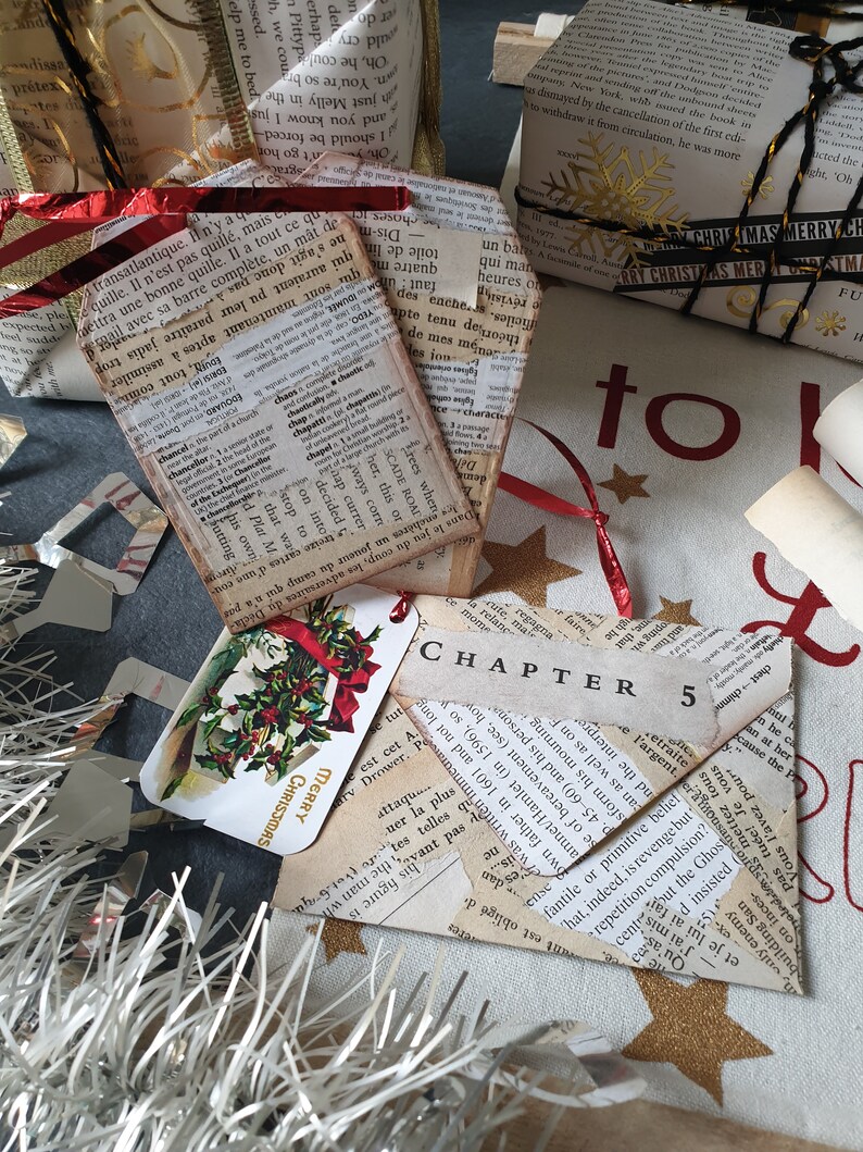 May include: Christmas-themed gift tags and wrapped presents. The gifts are wrapped in paper made from book pages, with red ribbon and gold accents. One tag reads "Merry Christmas" and another says "Chapter 5".