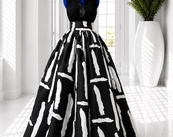 May include: A sleeveless black bodice dress featuring a high waist and a full-length skirt. The skirt is black with a bold, white, abstract brushstroke pattern. The bodice has a simple round neckline and a vertical center seam detail.
