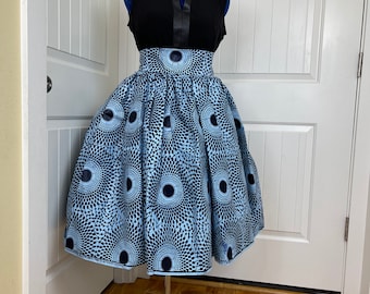 May include: A blue and black patterned skirt with a high waistline. The skirt is full and flowing, and it is being displayed on a mannequin.