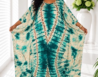 May include: A floor-length kaftan dress featuring a tie-dye pattern in shades of teal, dark green, and cream. The garment has a loose, flowing silhouette with wide sleeves, a round neckline, and a symmetrical vertical design down the center.