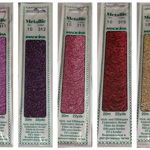 May include: Five spools of metallic embroidery thread in pink, purple, light pink, red, and gold. Each spool is labelled "Metallic" with the Madeira logo and the thread number and colour. Each spool contains 20 metres (22 yards) of thread.