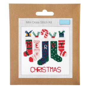 May include: A Mini Cross Stitch Kit by Trimits in brown packaging. The design features five colorful Christmas stockings with patterns, each topped with a festive element, spelling MERRY CHRISTMAS in red and green stitched letters on white fabric.