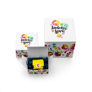 May include: Three white gift boxes with colorful floral designs and the text "Ludowe Love" on the top. The smallest box is open and contains a yellow gift bag with a blue and white floral design.