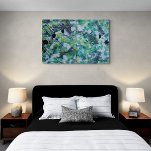 May include: A black bed frame with a white and black striped comforter. Two bedside tables with lamps are on either side of the bed. A large abstract painting with green, black, and white colors hangs on the wall above the bed.