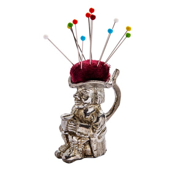A hand-cast pewter Toby Jug — a tiny Victorian character mug — repurposed as a pincushion, made by Sheffield craftspeople with real heritage behind it.