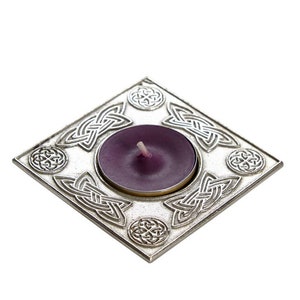 May include: A silver square tea light holder with a Celtic knot design and a purple tea light candle.