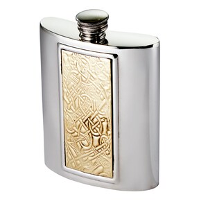 May include: A polished silver-tone metal flask with a curved rectangular body and a screw-top cap. The centre of the flask features a rectangular inset panel with a raised, intricate gold-tone relief pattern of interwoven knotwork designs.