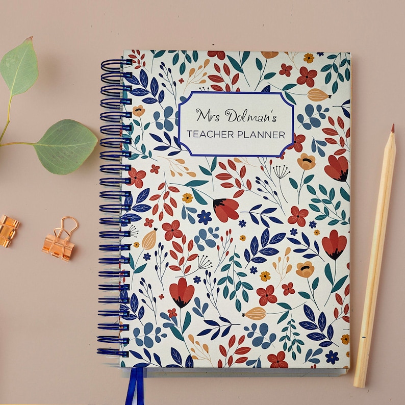 (Blue floral) Wire bound Teacher Planner, available in A4 5, 6, 7, 8, 9 & 10 lessons, A4 5 & 6 dated lesson & A5 5, 6 & 7 lessons. Red & Blue flower design on the cover, personalisation, choice of different coloured wire & ribbon, plastic pocket.