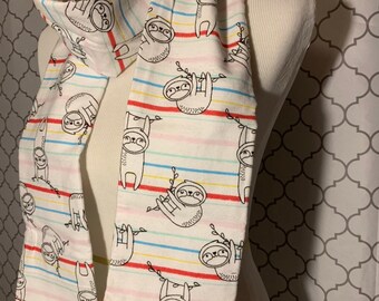 May include: White infinity scarf with a colorful stripe pattern and a repeating print of sloths hanging from branches.