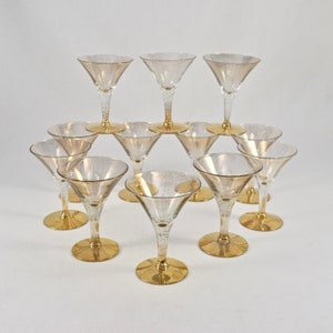 May include: Set of twelve gold-rimmed, clear glass martini glasses with a speckled finish. The glasses are arranged in a pyramid shape.