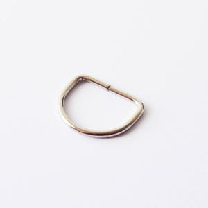 Op de afbeelding: Een zilveren metalen D-ring, een type hardware dat wordt gebruikt voor het bevestigen van banden, kettingen of andere accessoires.