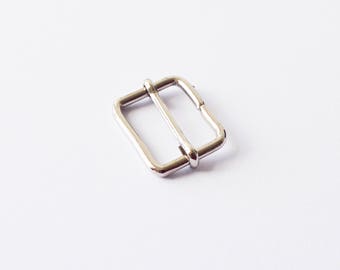 May include: A silver metal buckle with a rectangular shape and a smooth finish.