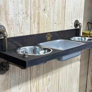 Floating water bin dual feeder: steampunk pet feeding station with two stainless bowls on a wooden platform beside a dog.