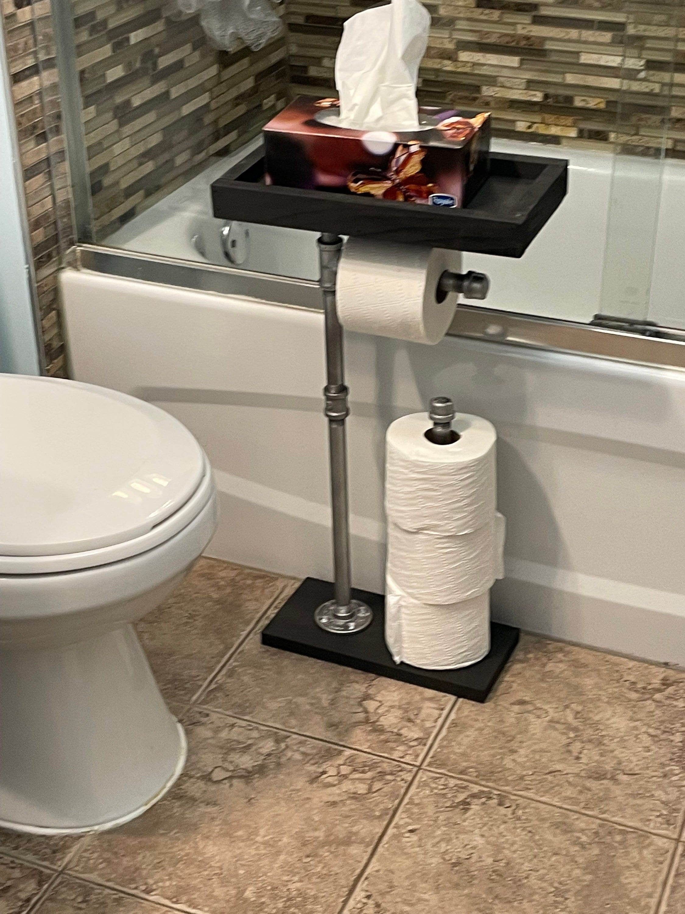 Toilet paper holder placed between bathtub and toilet