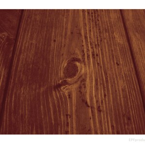 May include: Close-up of a dark brown wood grain surface with a knot in the center. The wood has a natural, rustic look.