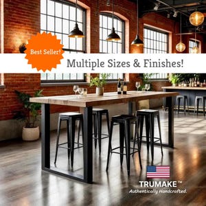 May include: A rustic wooden dining table with a black metal frame, paired with black metal bar stools. The image includes the text "Multiple Sizes & Finishes!" and the American flag with the text "TRUMAKE Authentically Handcrafted."