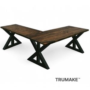 May include: L-shaped wooden desk with a dark brown tabletop and black metal X-shaped legs. The desk is made of wood and metal. The desk is designed for a home office or workspace.