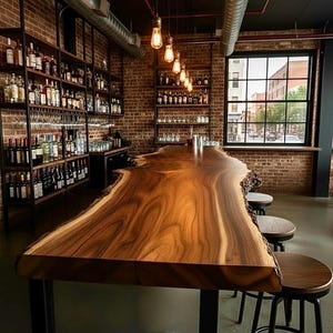 May include: A long bar counter made from a single slab of polished wood with a natural live edge, supported by a metal frame. The bar is accompanied by several round wooden stools with black metal legs, set against a backdrop of brick walls.