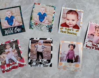 Könnte beinhalten: Sechs bunte Fotoautomatenrahmen mit verschiedenen Designs und Texten. Jeder Rahmen zeigt ein Baby in einer anderen Pose. Die Rahmen beinhalten ein Wassermelonen-Design mit dem Text "Sam's Sweet Sixteen", ein Kuhfell-Design mit dem Text "Holy Cow Sean's One", ein tropisches Design mit dem Text "Wild One", ein Bienen-Design mit dem Text "Tyler's First Beeday", ein Pfirsich-Design mit dem Text "Olivia is One Sweet Peach" und ein rosa-weißes Punkte-Design mit dem Text "Hazel's Berry 1st Birthday".