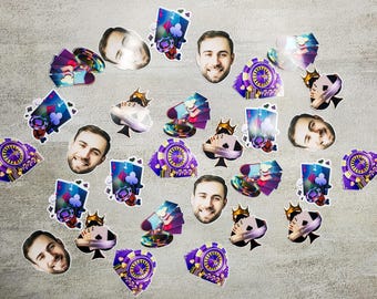 May include: A set of colorful party decorations featuring playing cards, poker chips, and faces. The decorations are printed on cardstock and have a glossy finish.