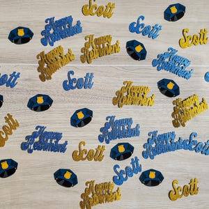 May include: Blue and gold glitter confetti with the words "Happy Retirement" and "Scott". There are also blue glitter police officer hats.
