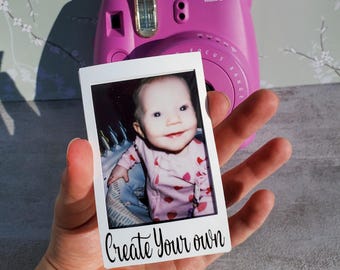 Könnte beinhalten: Eine fuchsiafarbene Instax Mini 8 Sofortbildkamera mit einem Babyfoto. Das Foto wird vor der Kamera gehalten, mit dem Text "Create Your Own" am unteren Rand.