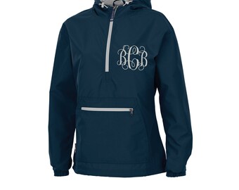 May include: A navy blue hooded pullover jacket with a zipper and a white monogram on the front. The jacket has a kangaroo pocket and a drawstring hood.