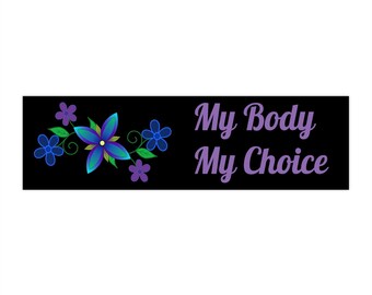 Può includere: Striscione nero con testo viola che recita "My Body My Choice". Un gruppo di fiori blu e verdi con centri viola si trova sul lato sinistro dello striscione.