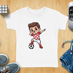 Cartoon child in Croatia soccer jersey dabs with a soccer ball.