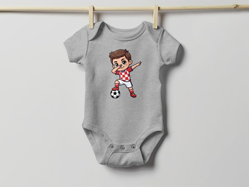 Baby bodysuit with a cartoon boy dabbing over a soccer ball.