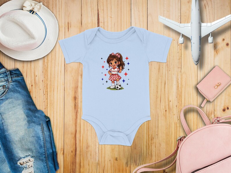 Light blue baby onesie with a cartoon girl playing soccer.