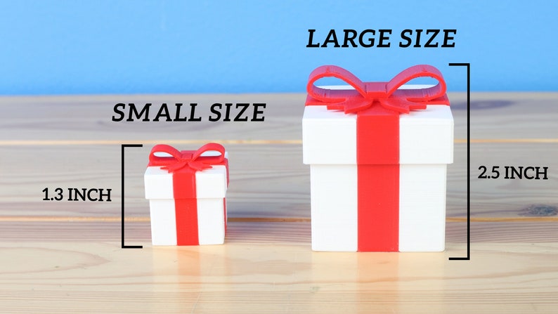 May include: Two white gift boxes with red ribbon and bows. The smaller box is 1.3 inches tall and the larger box is 2.5 inches tall.  SMALL SIZE and LARGE SIZE are written above the boxes.