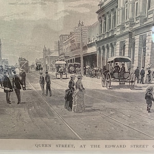 May include: A black and white illustration of a city street scene. The image shows a street with horse-drawn carriages and people walking. The street is lined with buildings, and there are trees in the background. The text "QUEEN STREET, AT THE EDWARD STREET C" is visible at the bottom of the image.