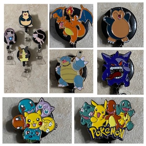 May include: A collection of colorful enamel badge reels featuring various Pokémon characters. The reels have black backgrounds and clear plastic clips. The characters include Pikachu, Charizard, and Snorlax, among others. These are ideal for fans of the popular franchise.