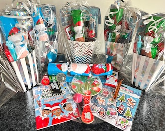 May include: A collection of Christmas-themed gift bags filled with small toys, candy, and other festive treats. The bags are decorated with Santa Claus, elves, and reindeer.