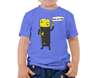 May include: A blue toddler t-shirt featuring a cartoon battery character with a yellow top and a black body. The battery has a lightning bolt and the text "Ponte Las Pilas" in a speech bubble. The shirt is worn by a young child.