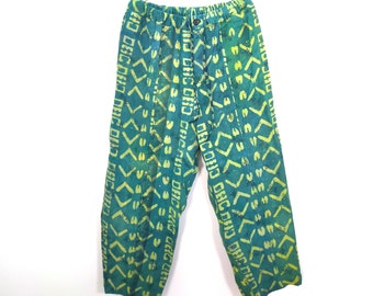 Könnte beinhalten: Grüne Hose mit gelbem geometrischem Muster und dem Text "ORCOND ONG DADD", der sich auf den Beinen wiederholt.