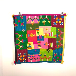 Könnte beinhalten: Ein farbenfroher Patchwork-Deckenbezug mit verschiedenen geometrischen und floralen Mustern in den Farben Rosa, Grün, Blau, Gelb und Rot.