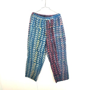 May include: Blue, pink, and yellow patterned pants hanging on a silver hanger. The pants have a drawstring waist and a relaxed fit.