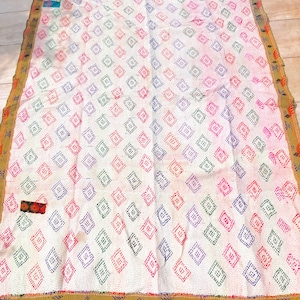 Könnte beinhalten: Eine weiße Kantha-Steppdecke mit einem Rautenmuster in Rosa-, Grün- und Lilatönen. Die Steppdecke hat einen goldenen und orangenen Rand.