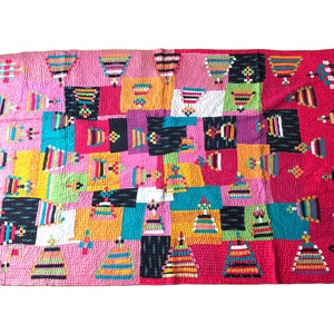 Puede incluir: Una colcha de retazos colorida con un patrón geométrico. La colcha está hecha de varias telas en tonos de rosa, rojo, amarillo, verde, azul y negro. La colcha está cosida a mano y tiene un aspecto único y hecho a mano.