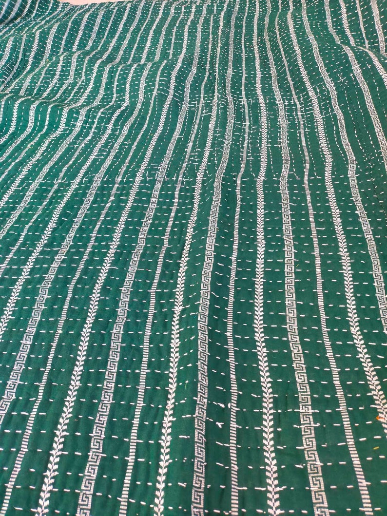 May include: A green kantha quilt with white stitching in a geometric pattern. The quilt is made of cotton and is hand-stitched.