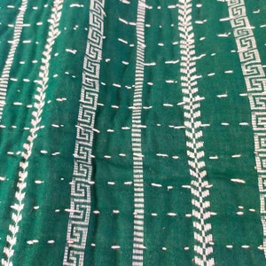 May include: Green fabric with white stitching in a geometric pattern. The fabric has a textured surface.