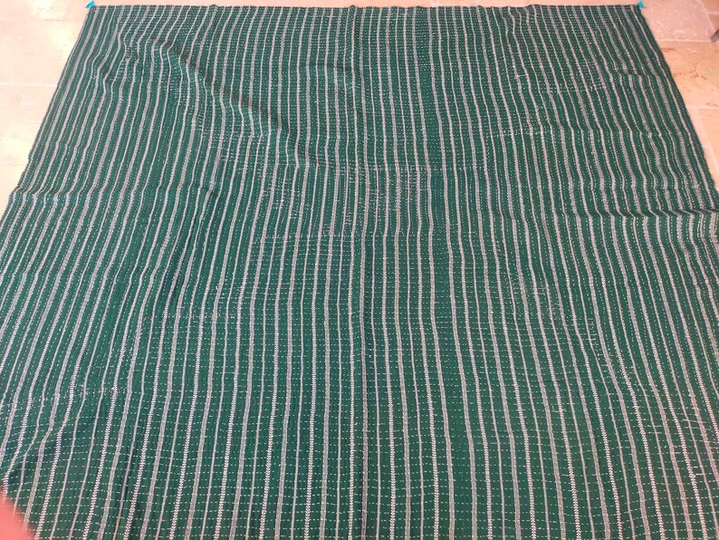 May include: A green and white striped fabric with a woven texture.