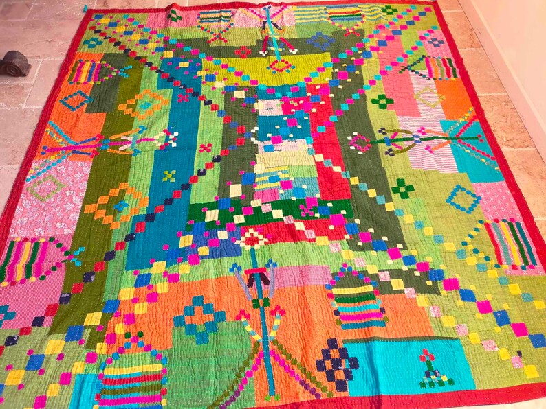 May include: A colorful patchwork quilt with geometric patterns in shades of red, orange, green, blue, pink, and yellow. The quilt is made of different fabrics sewn together to create a unique and vibrant design.