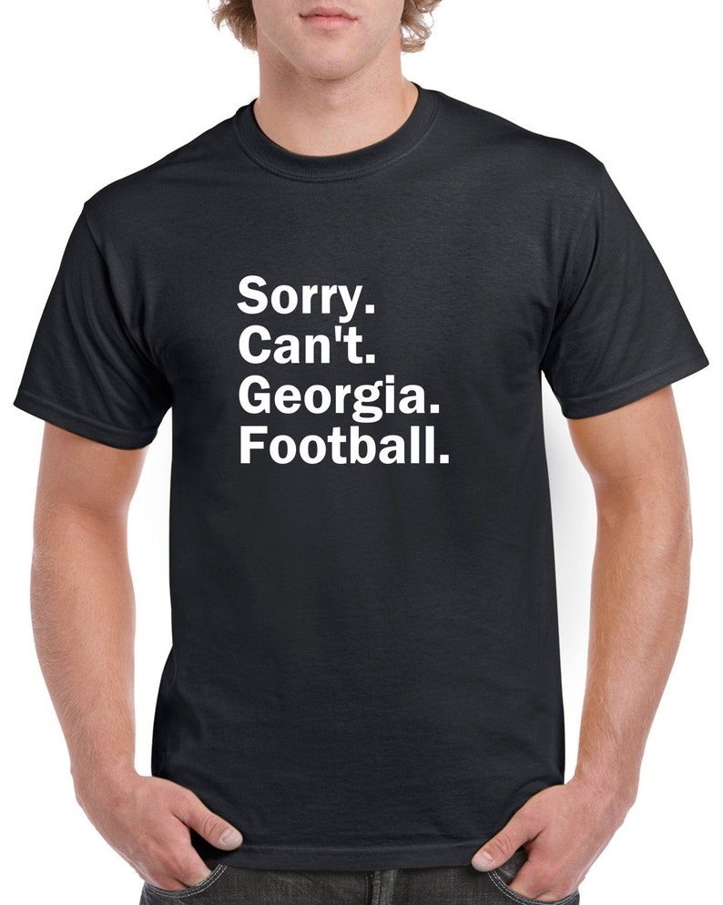 Puede incluir: Una camiseta negra con texto blanco que dice "Lo siento. No puedo. Georgia. F&uacute;tbol."