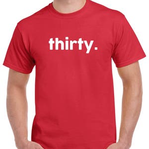 Puede incluir: Una camiseta roja con la palabra "thirty" impresa en blanco en la parte delantera.
