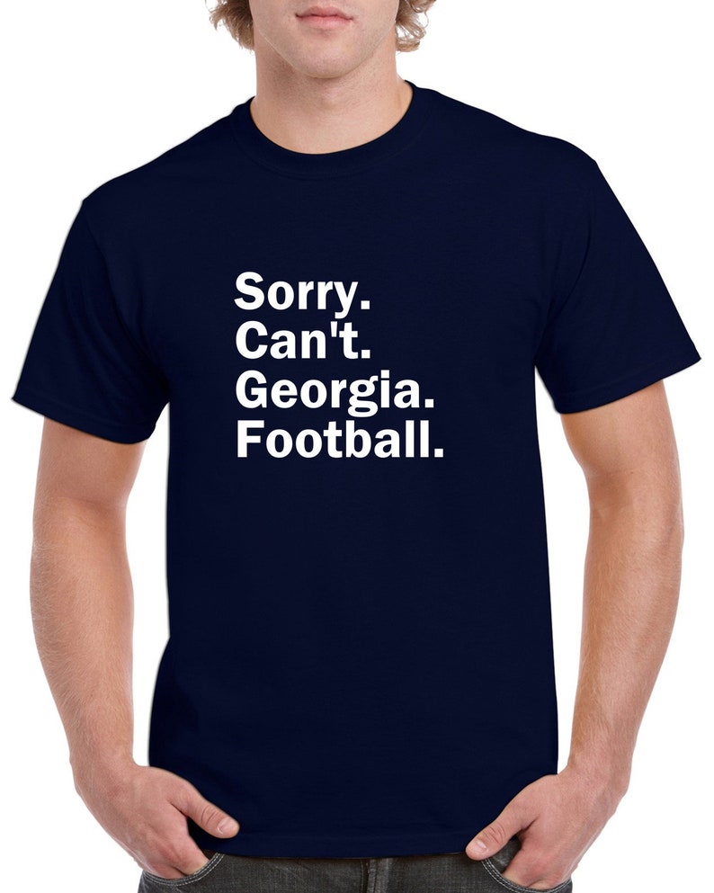 Puede incluir: Una camiseta azul marino con texto blanco que dice "Lo siento. No puedo. Georgia. F&uacute;tbol."