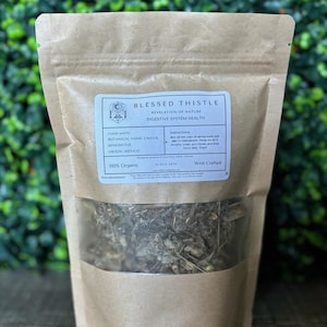 Könnte beinhalten: Ein brauner Papiersack mit einem transparenten Fenster, gefüllt mit getrockneten Kräutern. Der Beutel hat ein weißes Etikett mit dem Text "Blessed Thistle" und "Digestive System Health". Das Etikett enthält auch Anweisungen und den Text "100% Organic."
